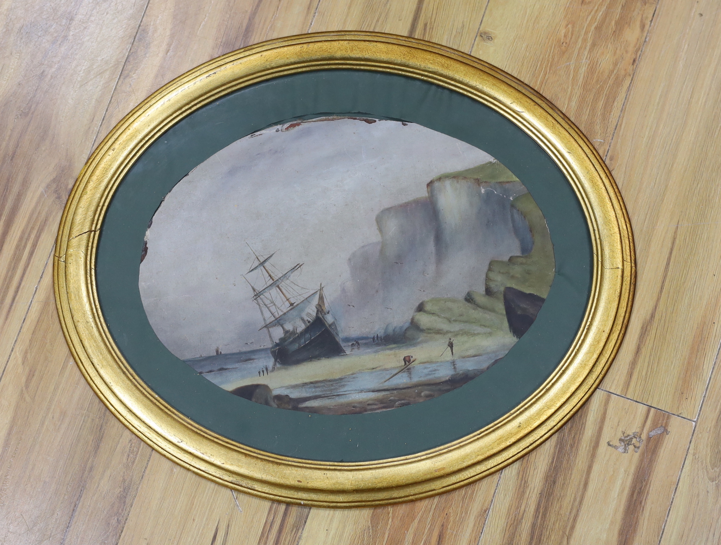 Late Victorian School, oval oil on unstretched canvas, Beached ship before cliffs, 40 x 28cm